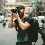 a man with a backpack taking a picture of himself