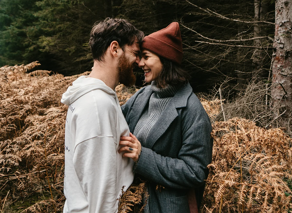 a man and woman standing in a field of plants